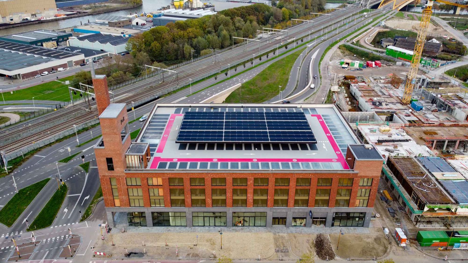 Een luchtfoto van een groot gebouw met zonnepanelen op het dak.