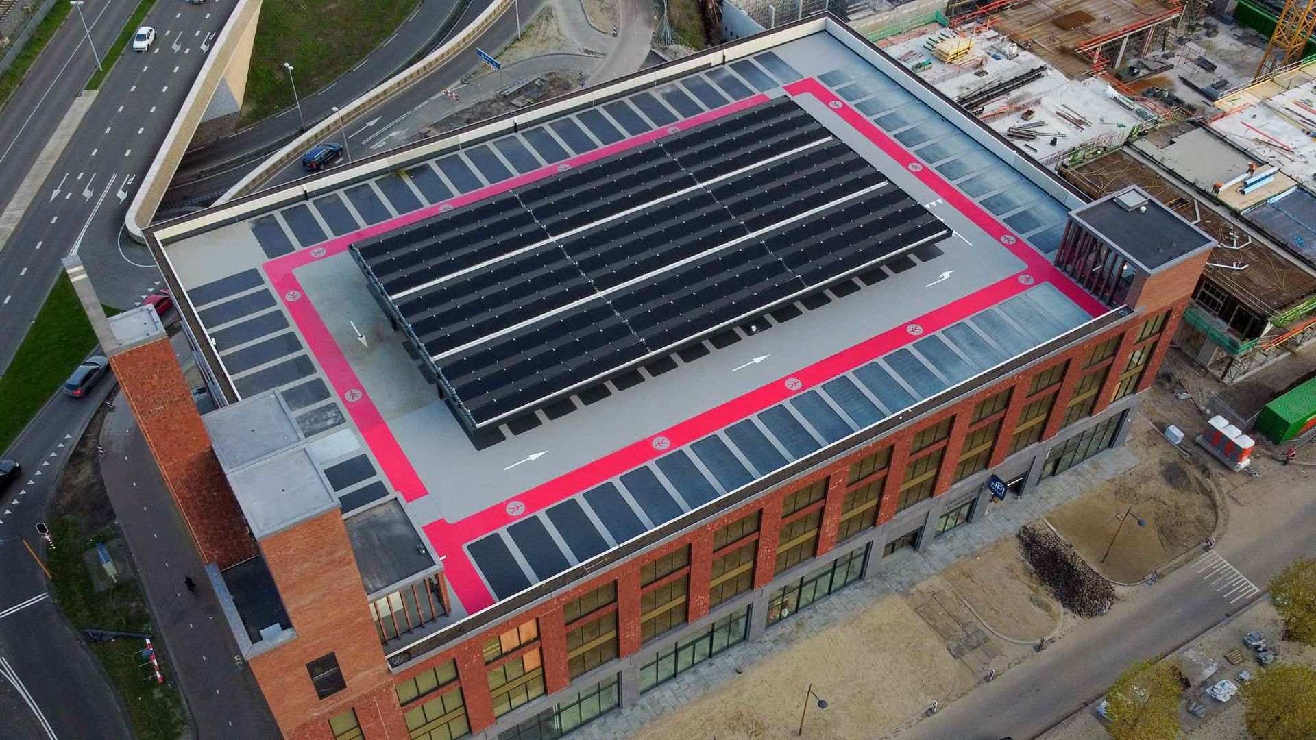 Een luchtfoto van een groot gebouw met zonnepanelen op het dak.