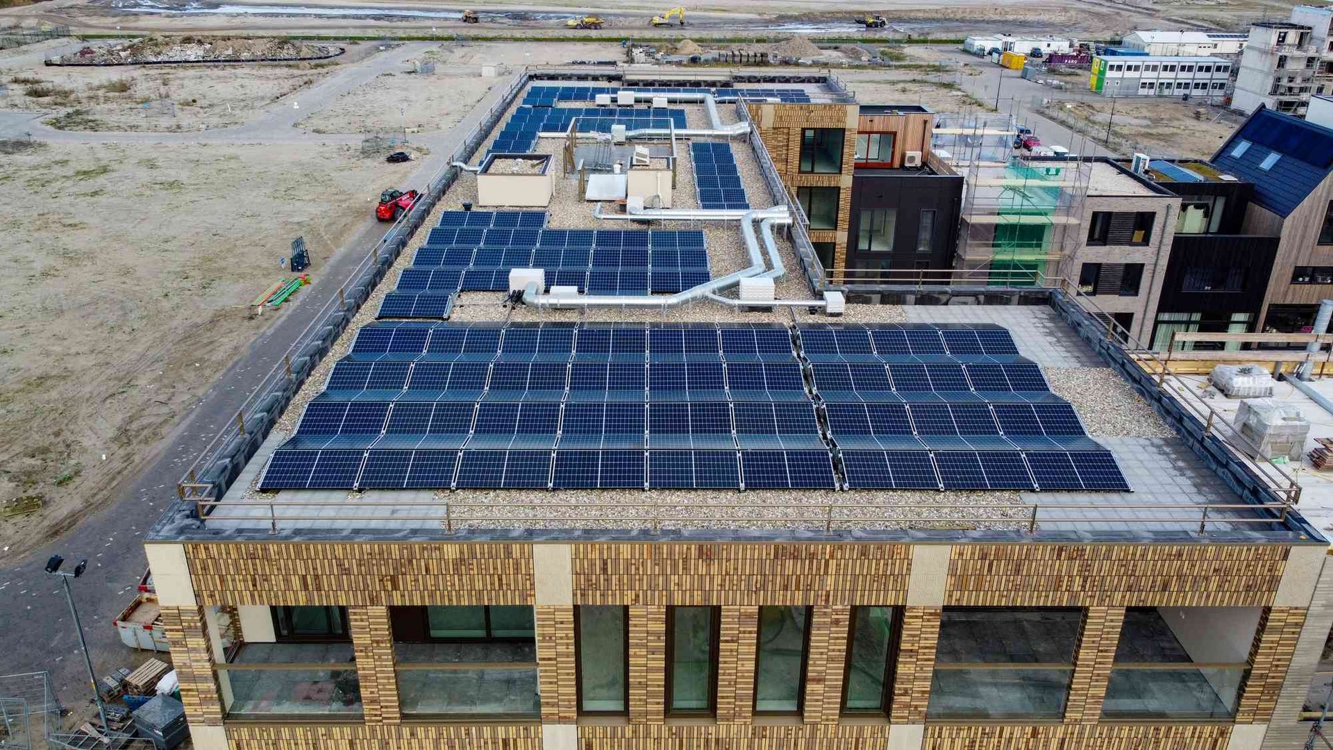 Een luchtfoto van een gebouw met zonnepanelen op het dak.
