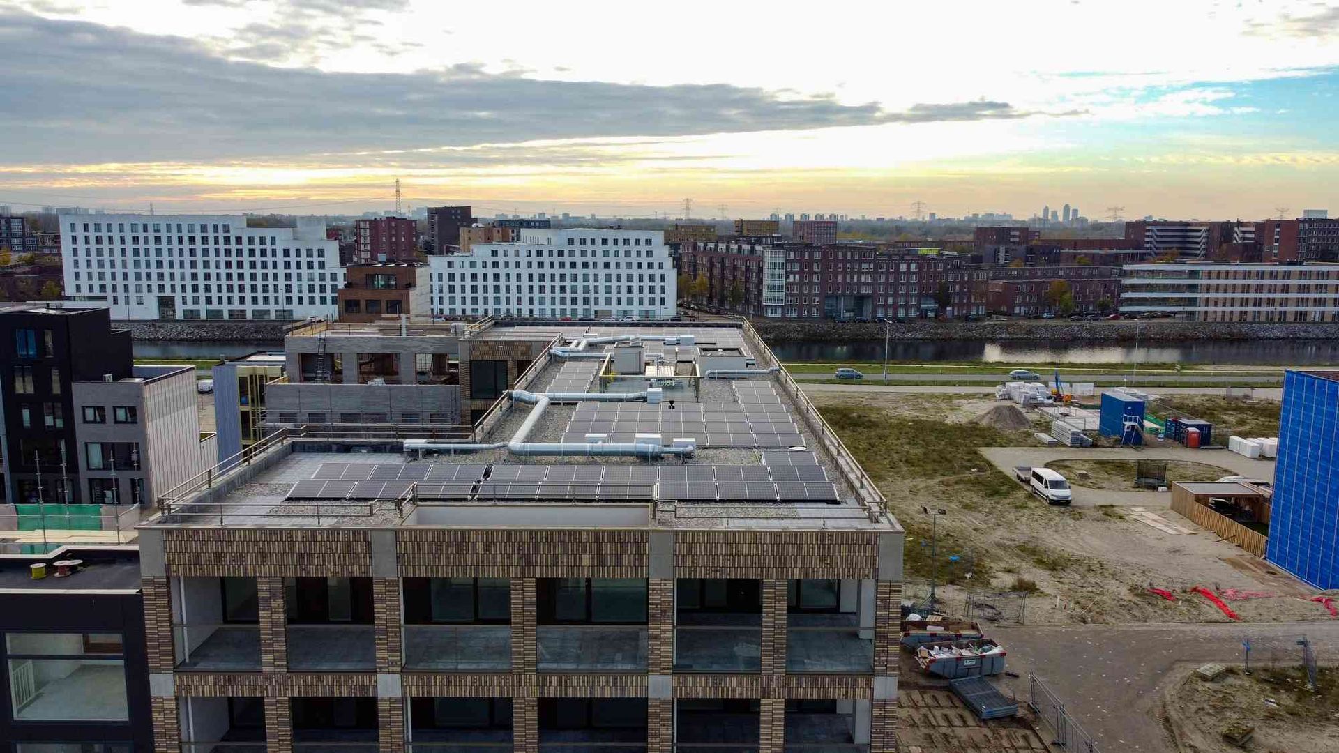 Een luchtfoto van een gebouw in aanbouw met zonnepanelen op het dak.