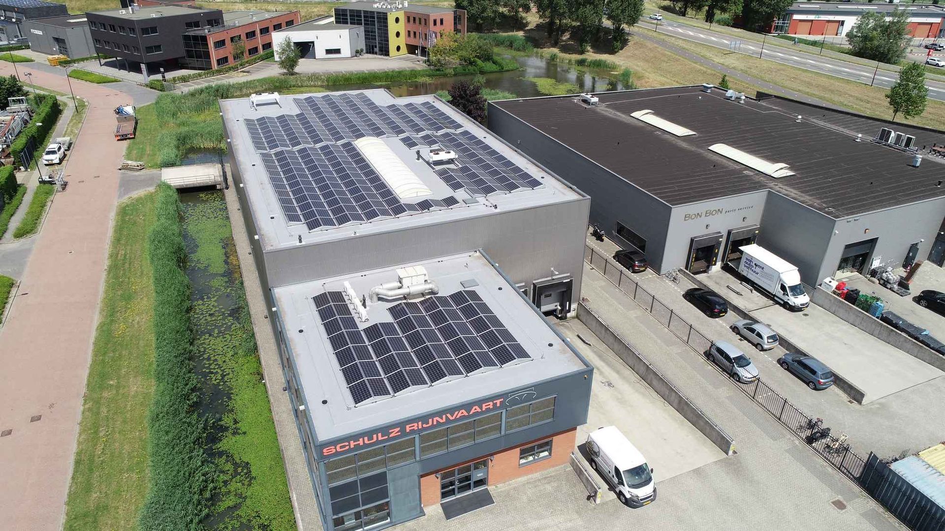 Een luchtfoto van een gebouw met zonnepanelen op het dak