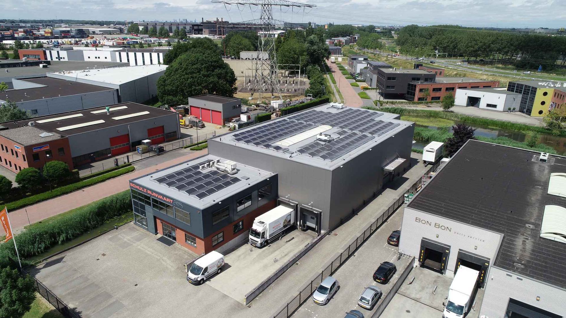 Een luchtfoto van een magazijn met zonnepanelen op het dak.