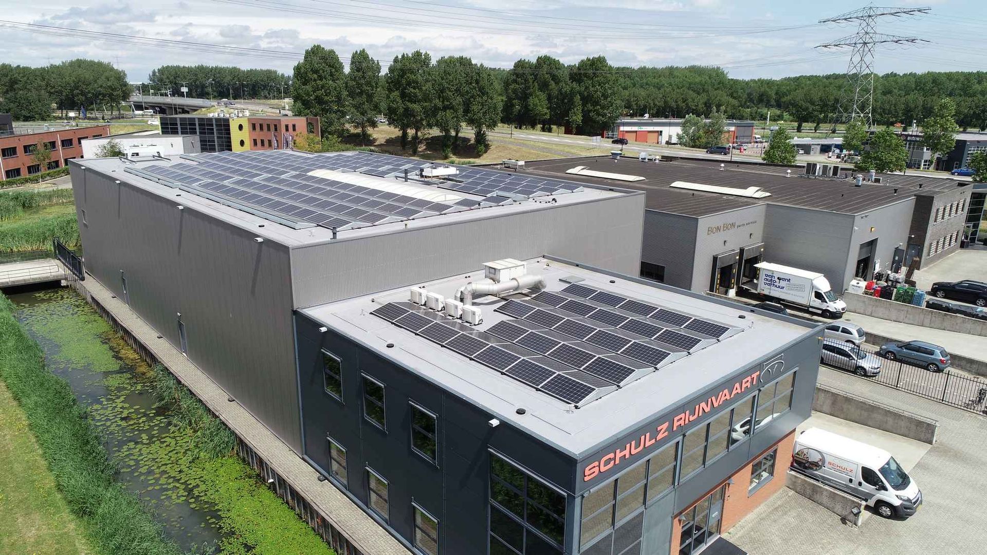 Een luchtfoto van een groot gebouw met zonnepanelen op het dak.
