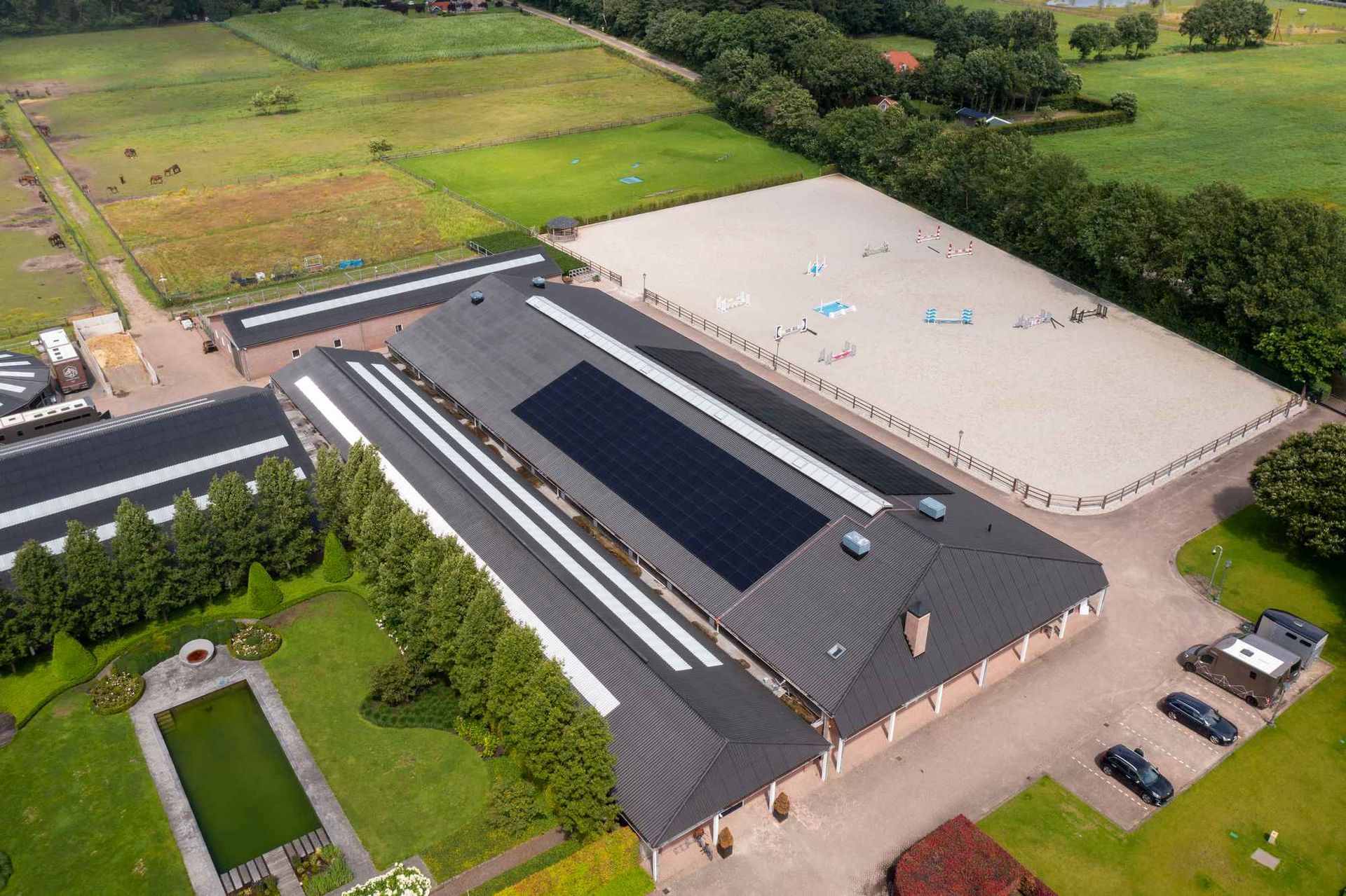 Een luchtfoto van een groot gebouw met zonnepanelen op het dak.