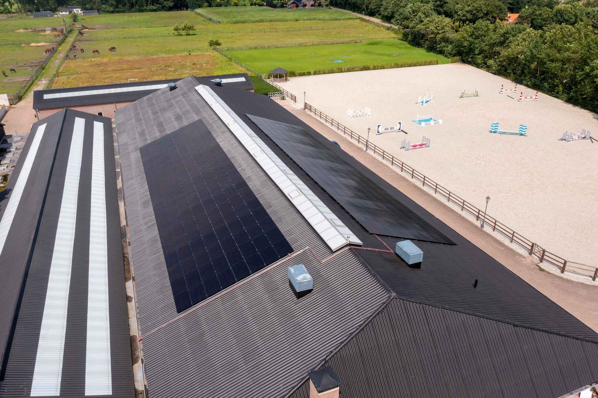 Een luchtfoto van een gebouw met zonnepanelen op het dak.