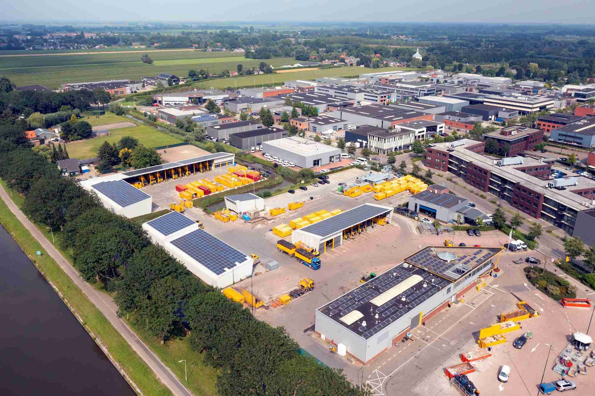 Een luchtfoto van een groot industriegebied met veel gebouwen en vrachtwagens.