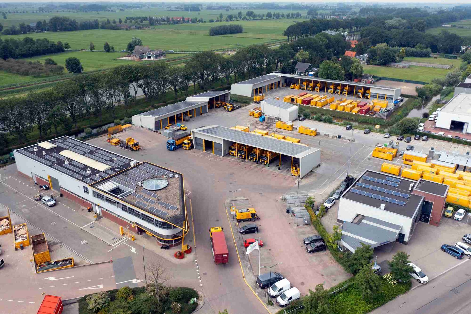 Een luchtfoto van een groot industriegebied met veel vrachtwagens en gebouwen