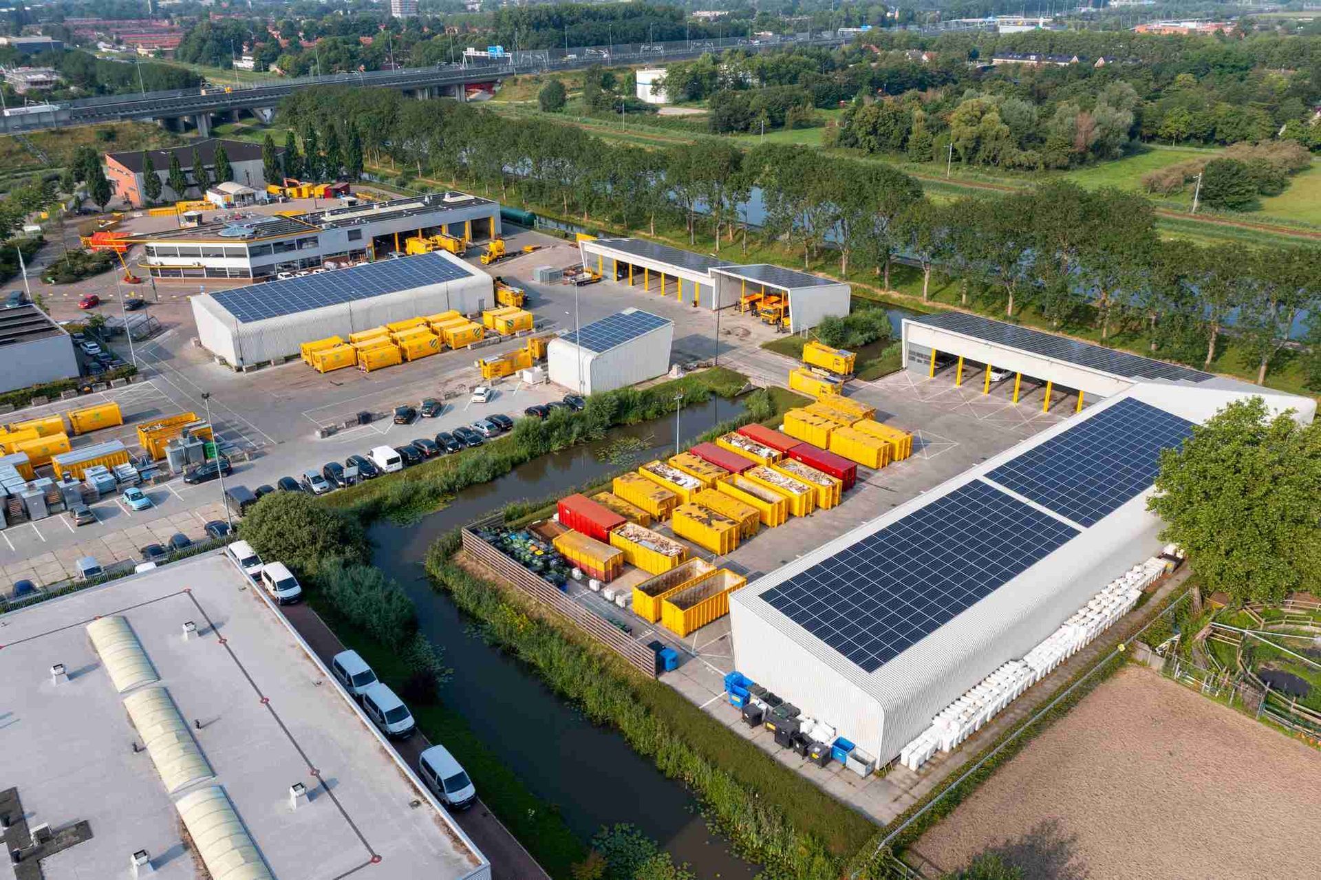 Een luchtfoto van een magazijn met zonnepanelen op het dak.
