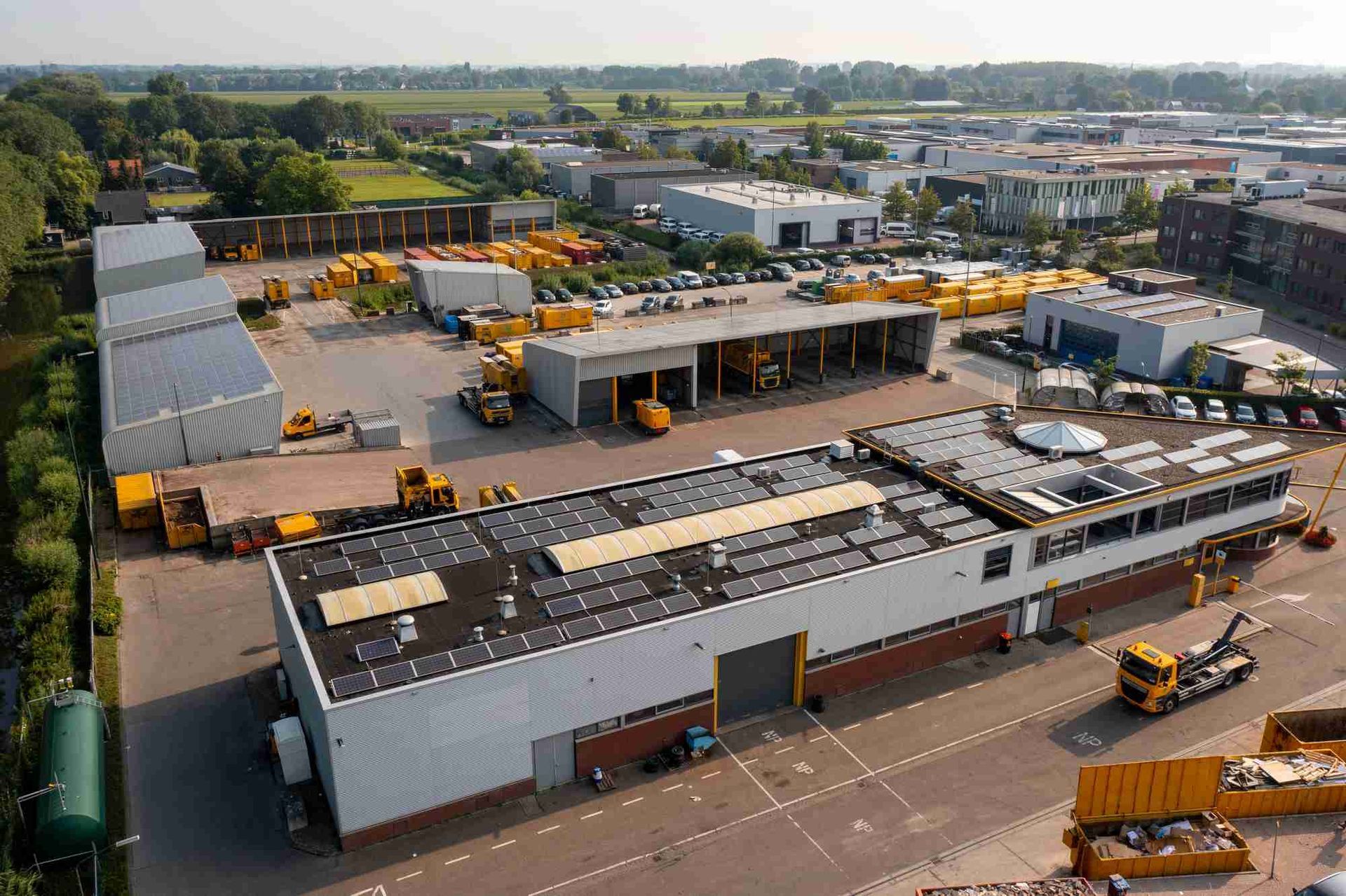 Een luchtfoto van een groot gebouw met veel vrachtwagens ervoor geparkeerd.