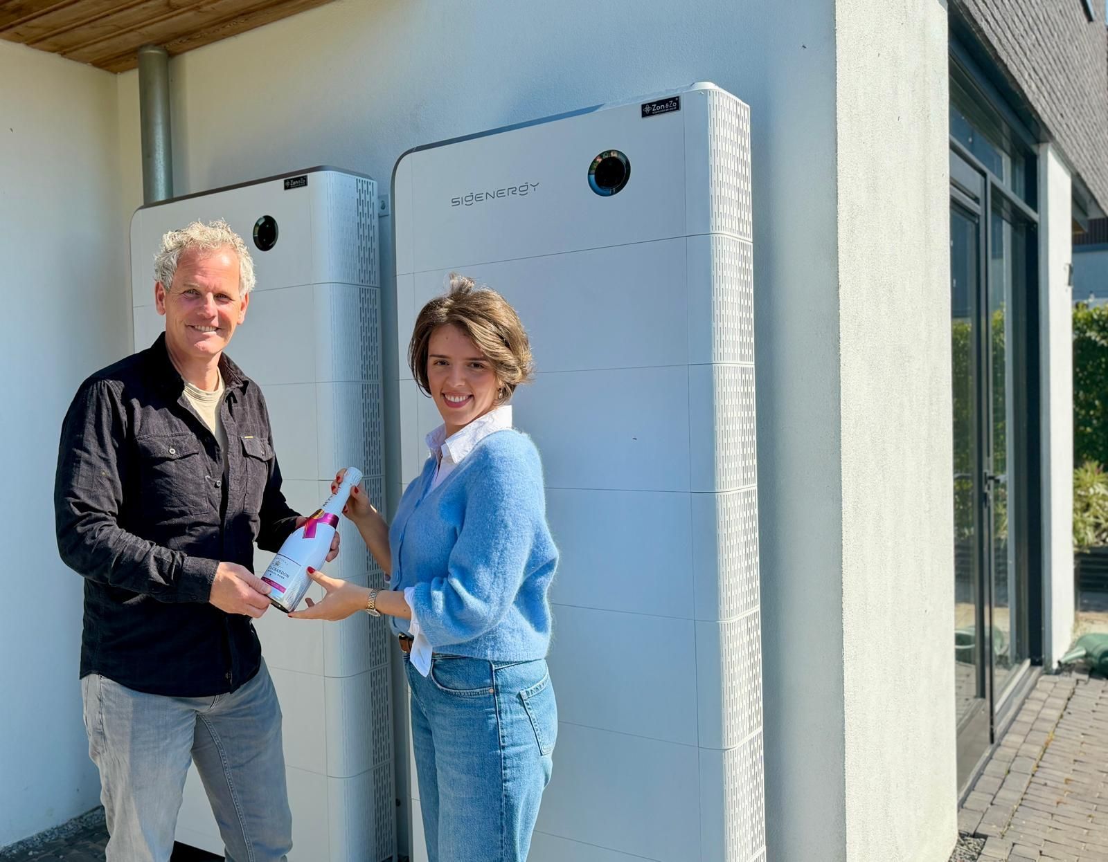Een man staat op een dak met zonnepanelen.
