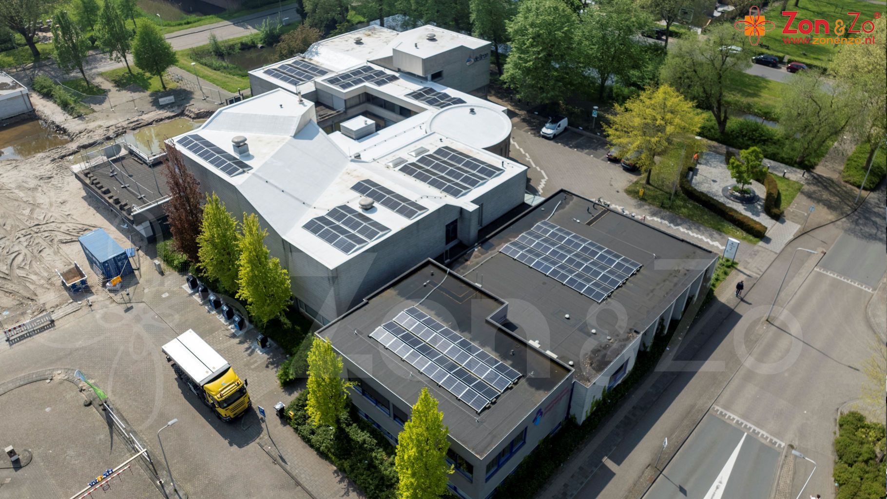 Een luchtfoto van een gebouw met zonnepanelen op het dak