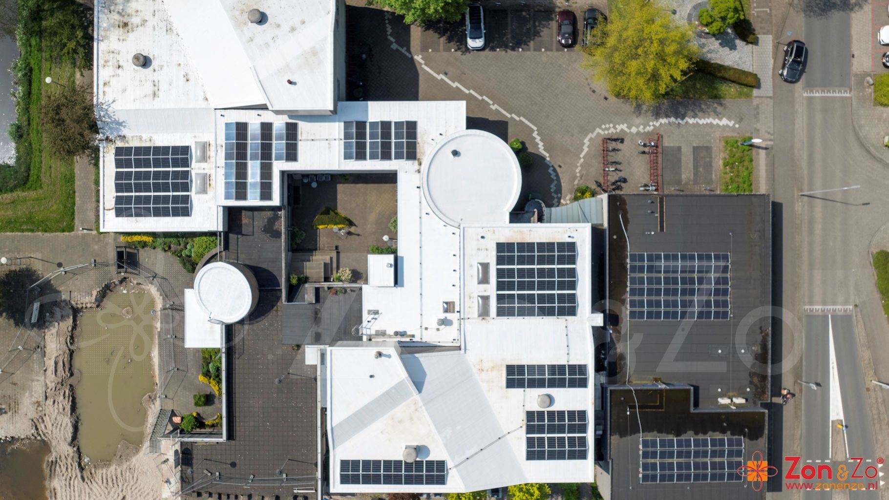 Een luchtfoto van een gebouw met zonnepanelen op het dak