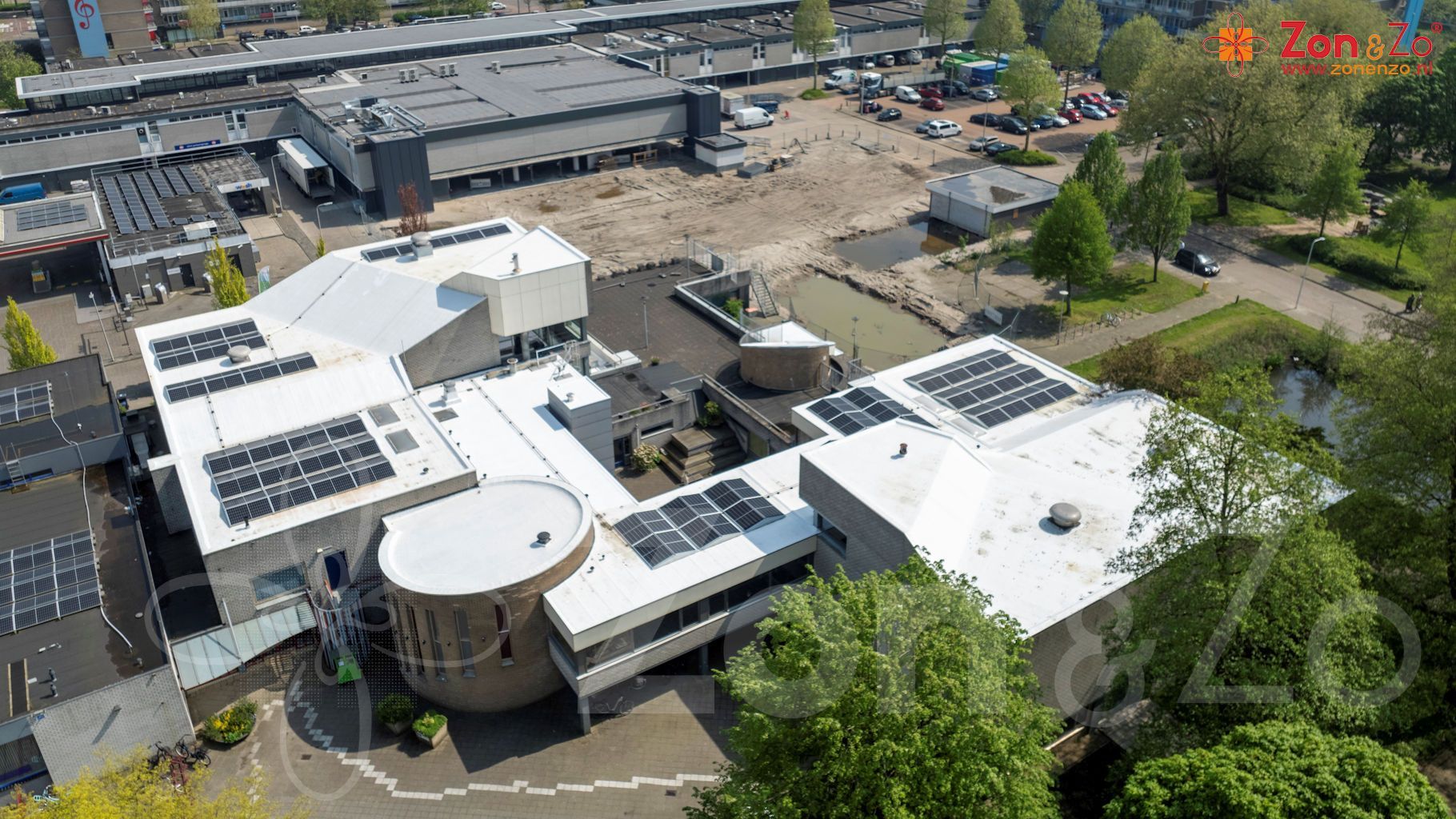 Een luchtfoto van een groot gebouw met zonnepanelen op het dak.