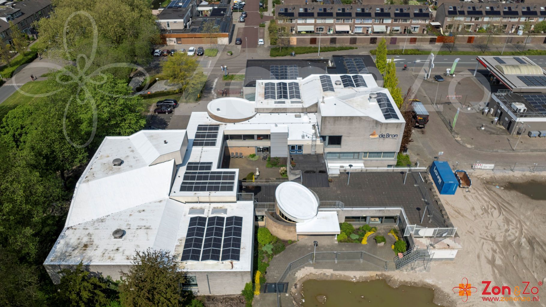 Een luchtfoto van een groot gebouw met zonnepanelen op het dak.