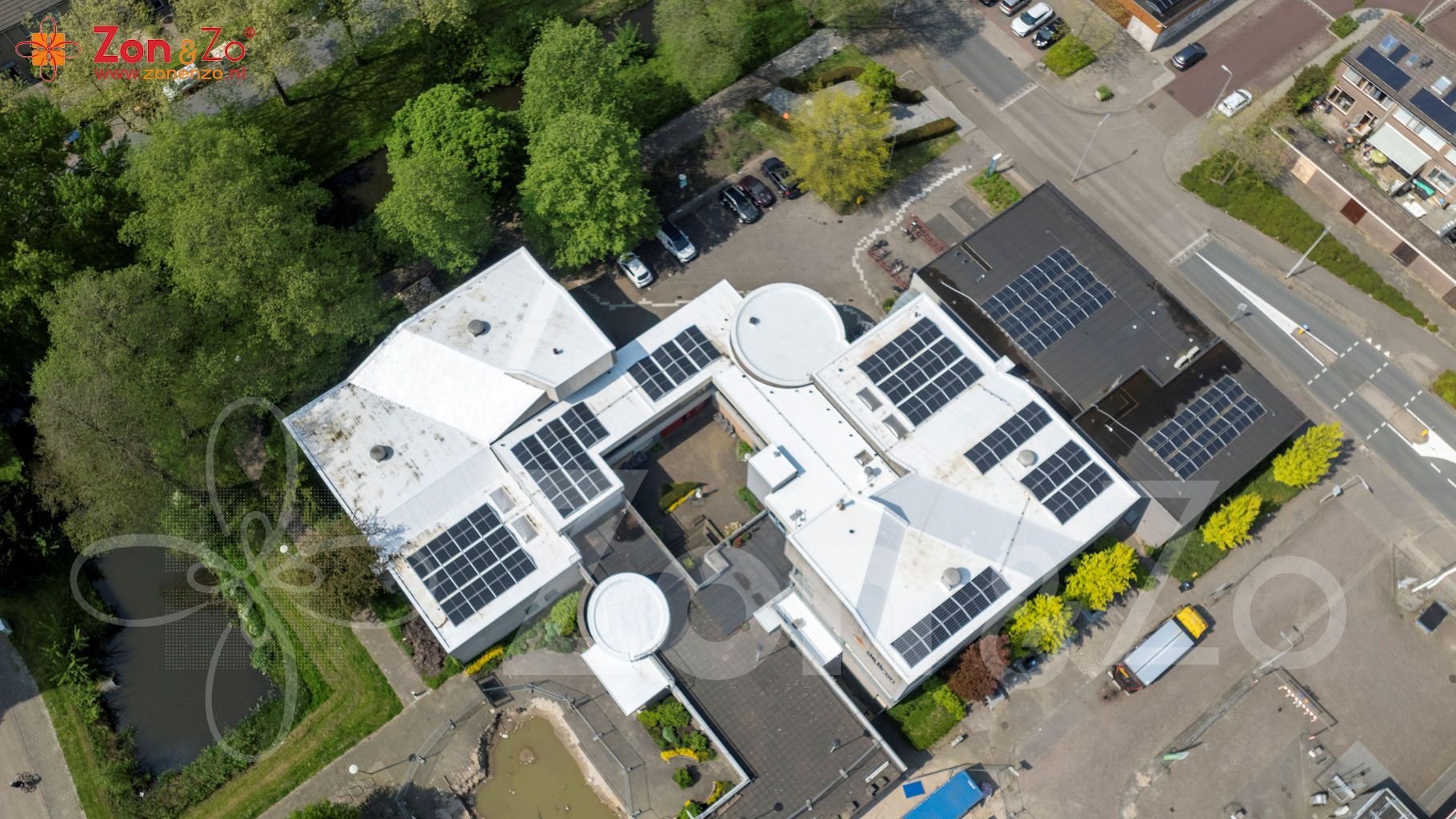 Een luchtfoto van een gebouw met zonnepanelen op het dak.