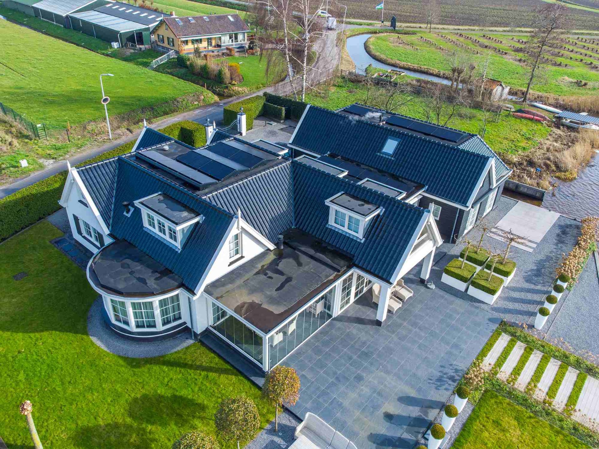 Een luchtfoto van een groot huis met zonnepanelen op het dak.