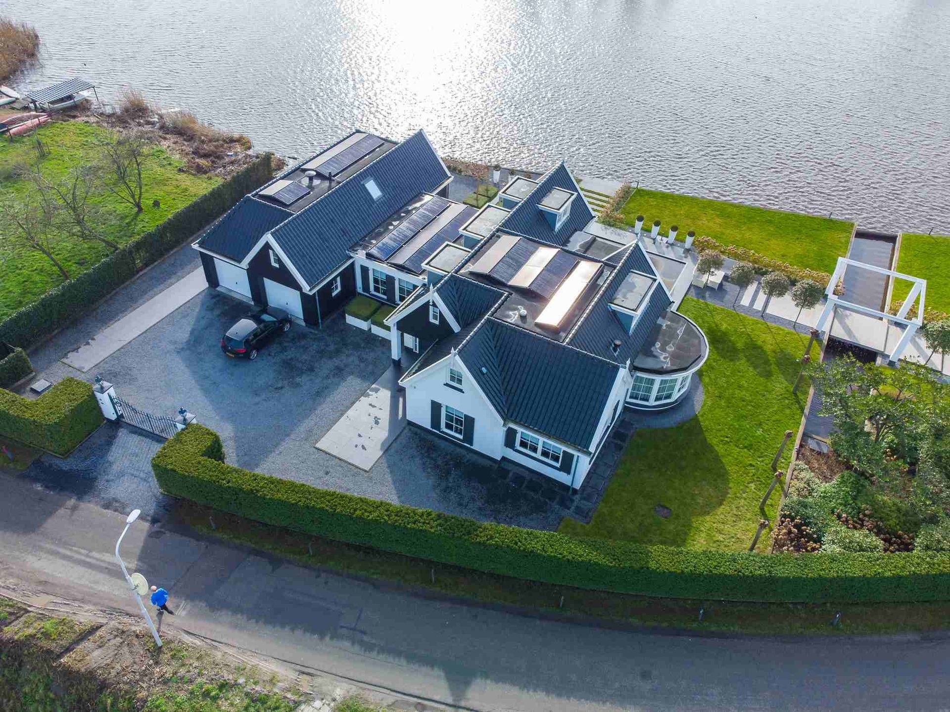 Een luchtfoto van een groot huis naast een waterpartij.