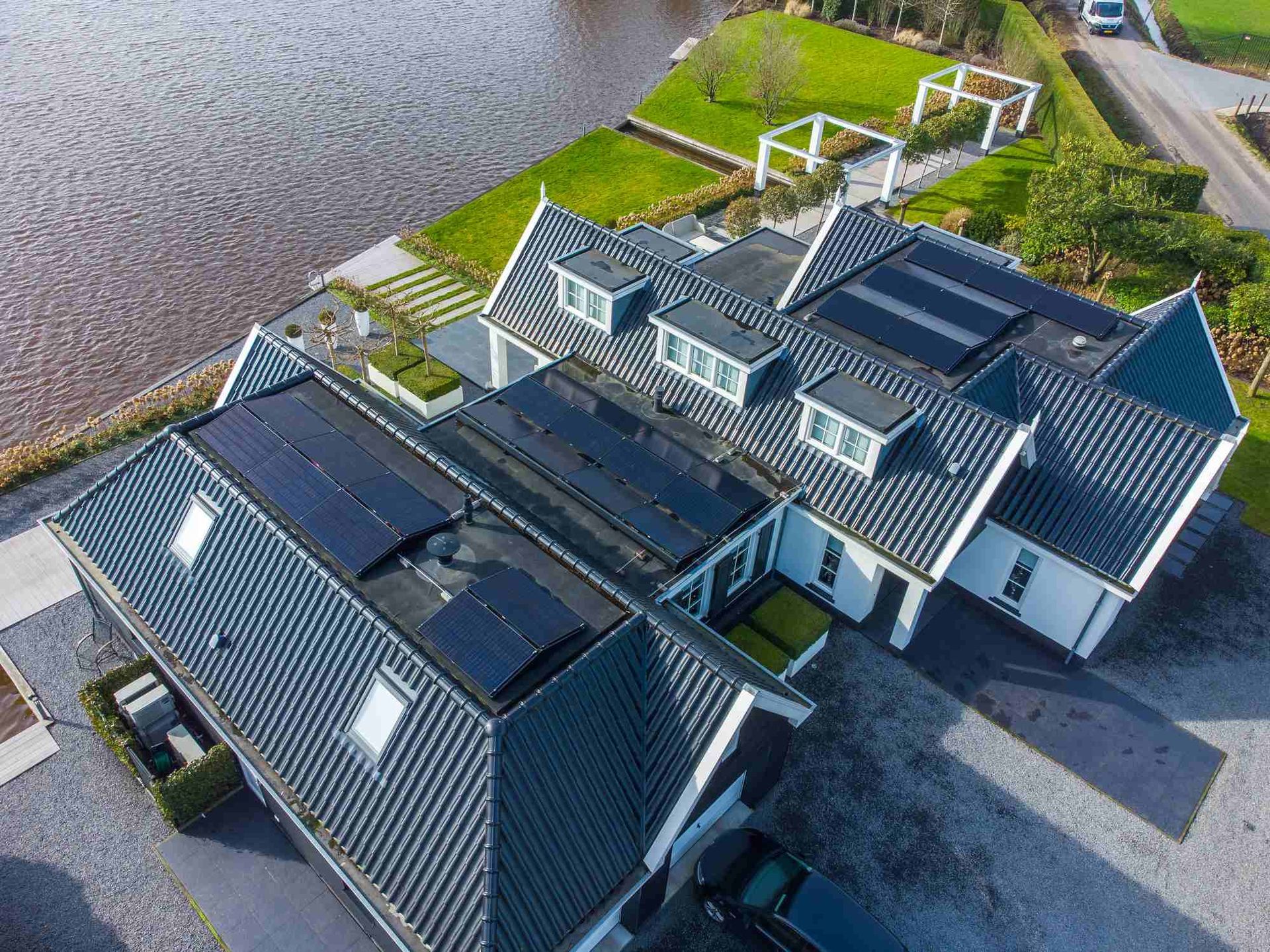 Een luchtfoto van een huis met zonnepanelen op het dak.