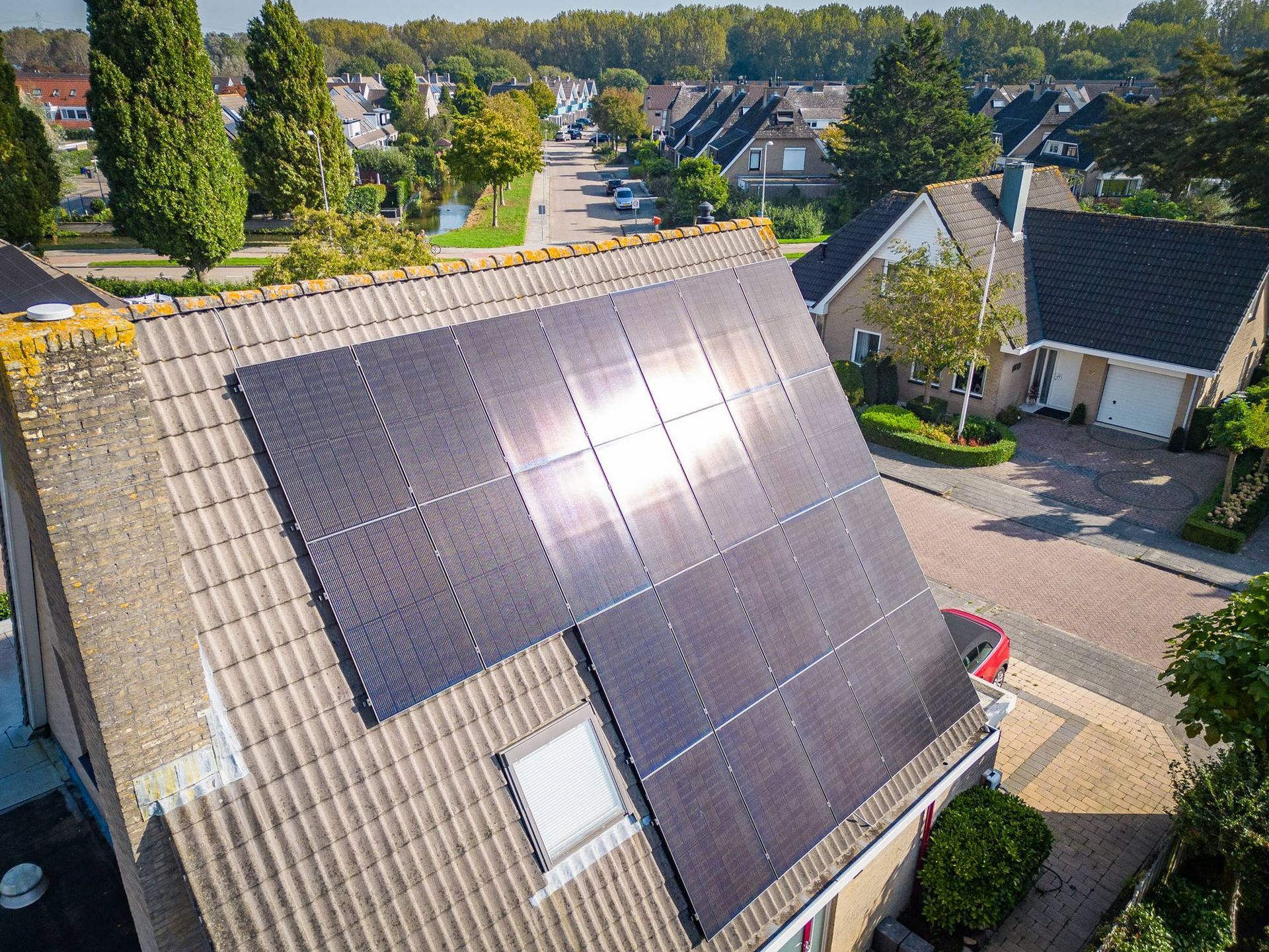 Een luchtfoto van een huis met zonnepanelen op het dak.