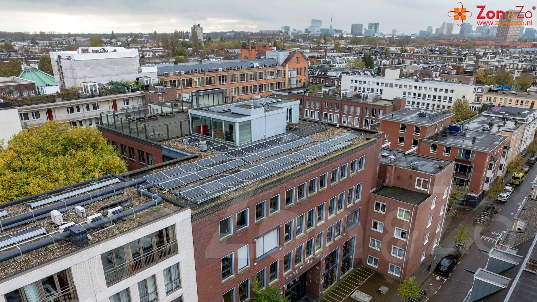 Een luchtfoto van een stad met een gebouw met zonnepanelen op het dak.