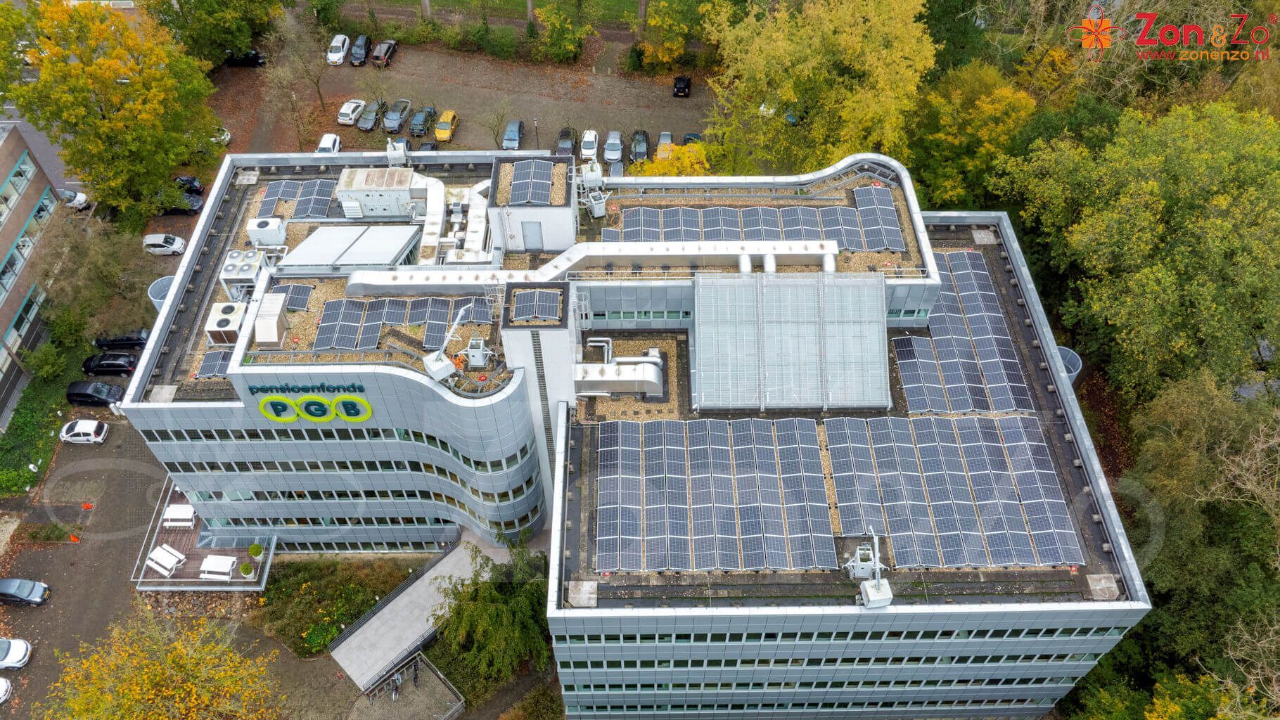 Een luchtfoto van een groot gebouw met zonnepanelen op het dak.