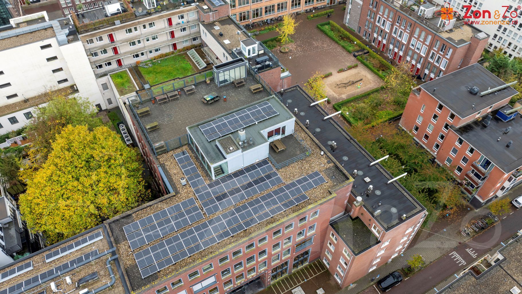 Een luchtfoto van een gebouw met zonnepanelen op het dak.