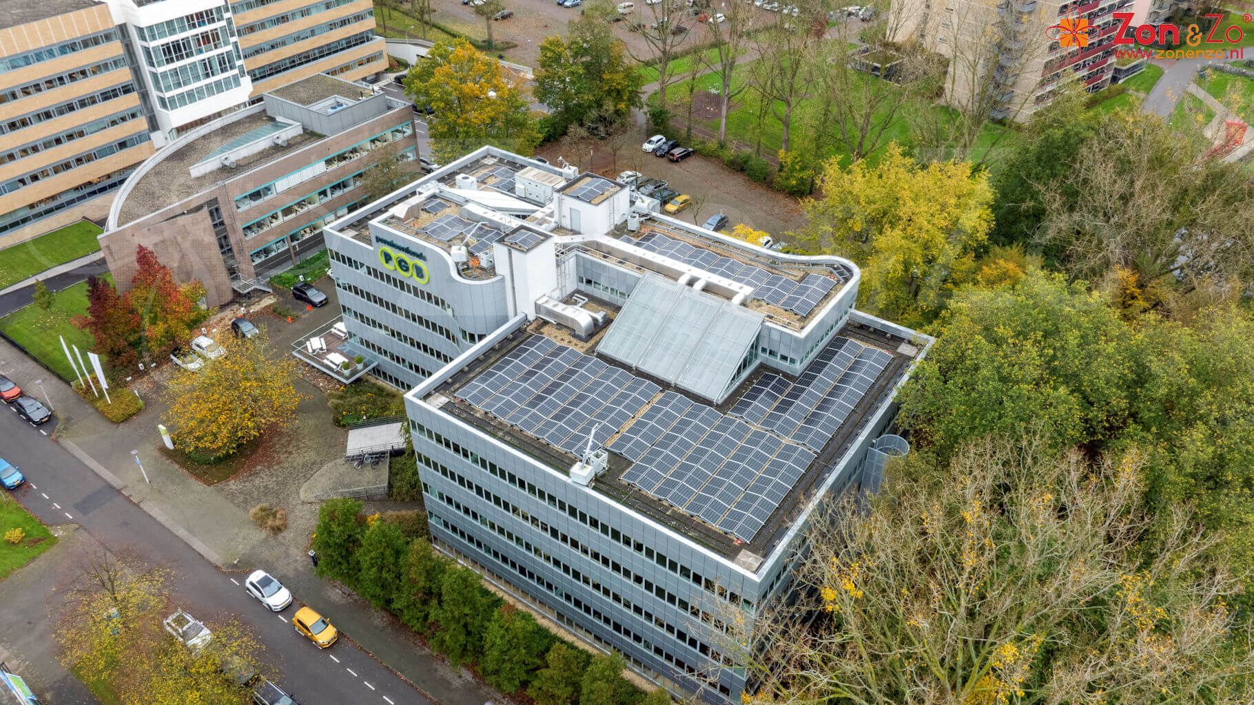 Een luchtfoto van een groot gebouw met zonnepanelen op het dak.