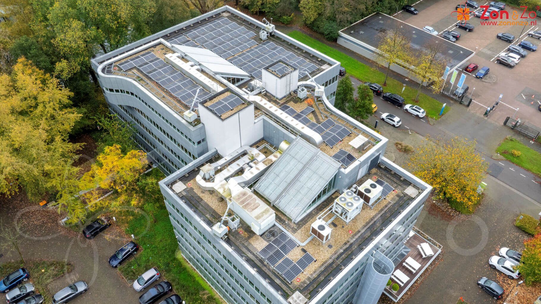 Een luchtfoto van een groot gebouw met zonnepanelen op het dak.