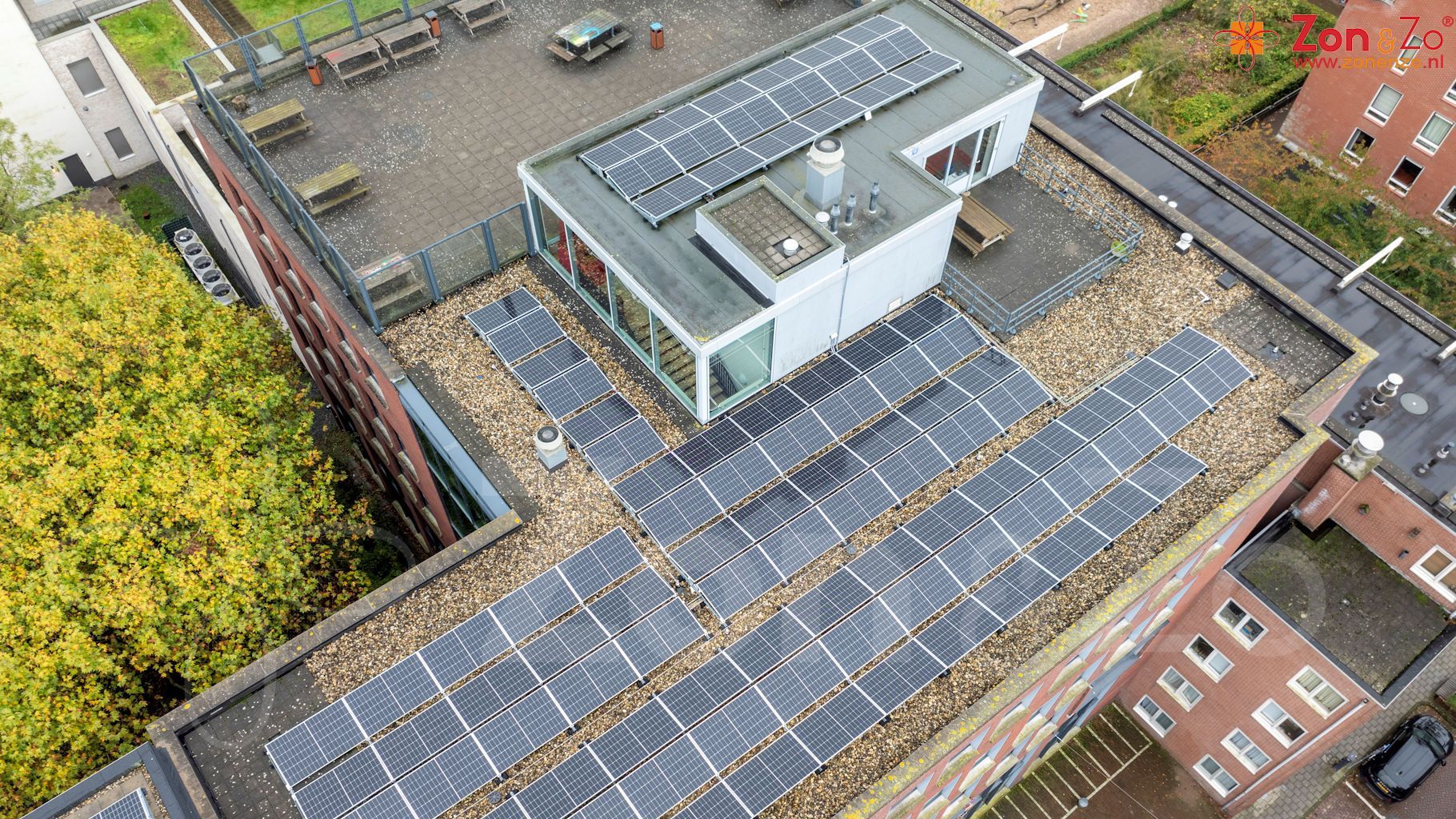 Een luchtfoto van een gebouw met zonnepanelen op het dak.