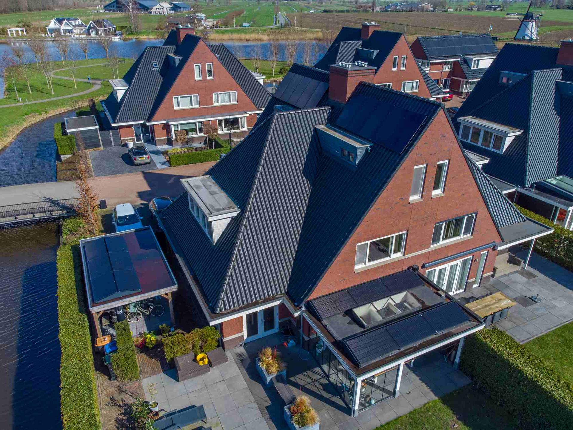 Een luchtfoto van een rij huizen met zonnepanelen op de daken