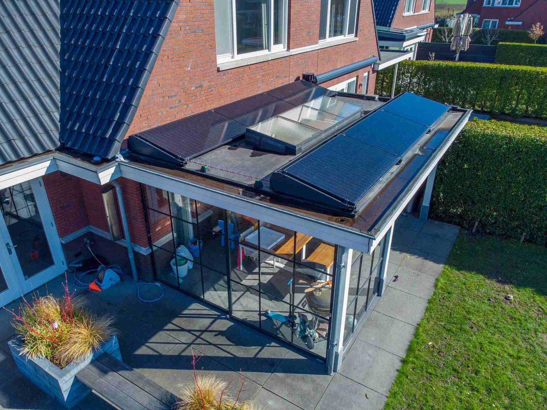 Een luchtfoto van een huis met zonnepanelen op het dak.
