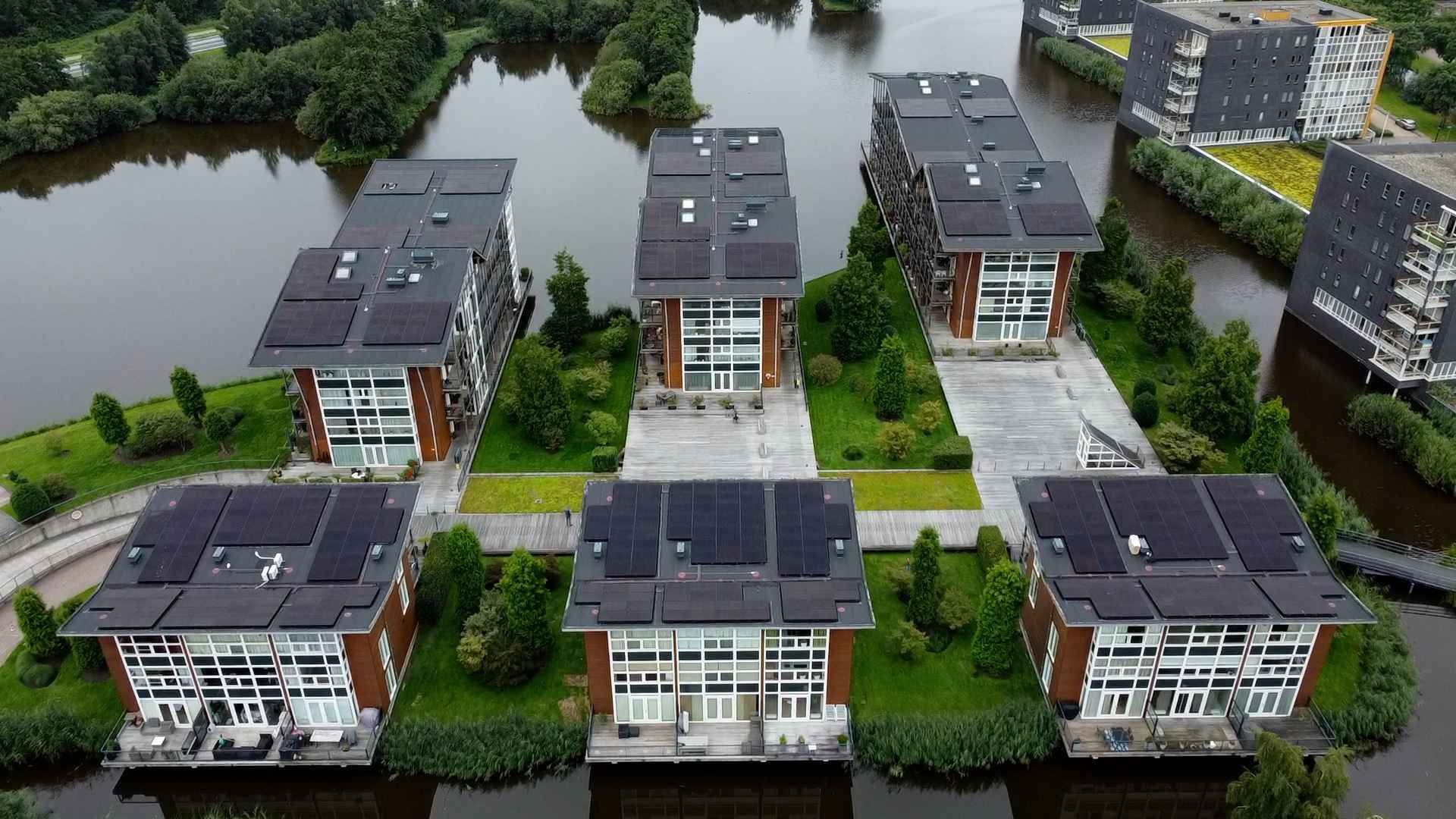 Een luchtfoto van een rij gebouwen langs een waterpartij.