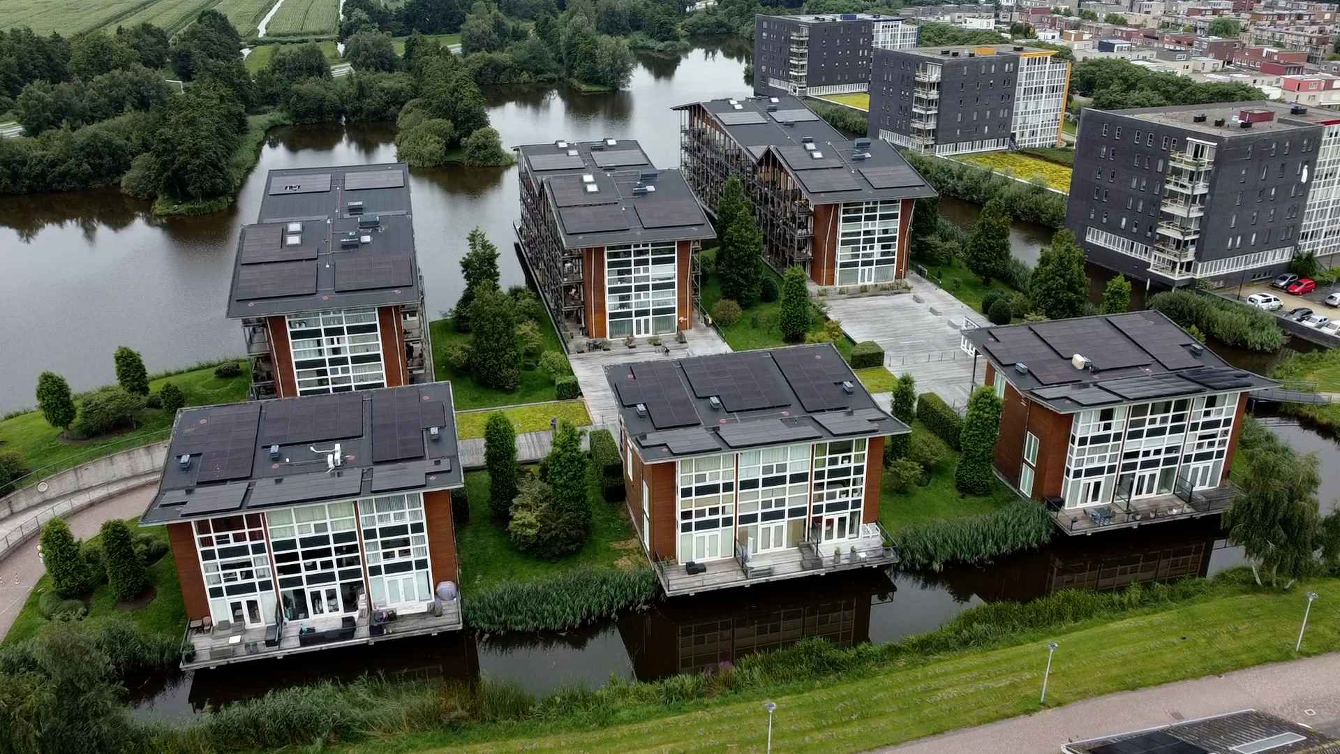 Een luchtfoto van een rij huizen aan een waterpartij.