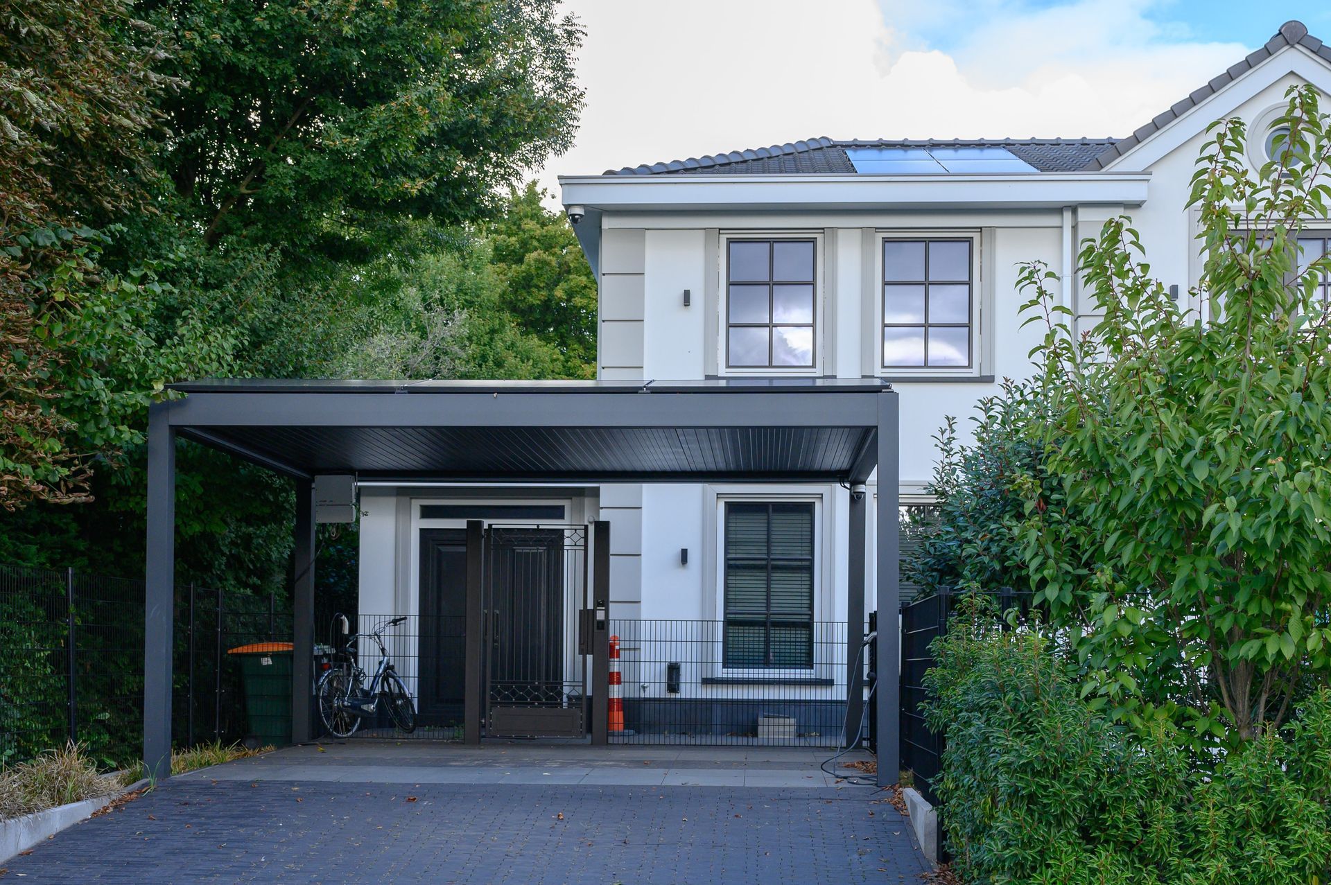 Een wit huis met een carport ervoor