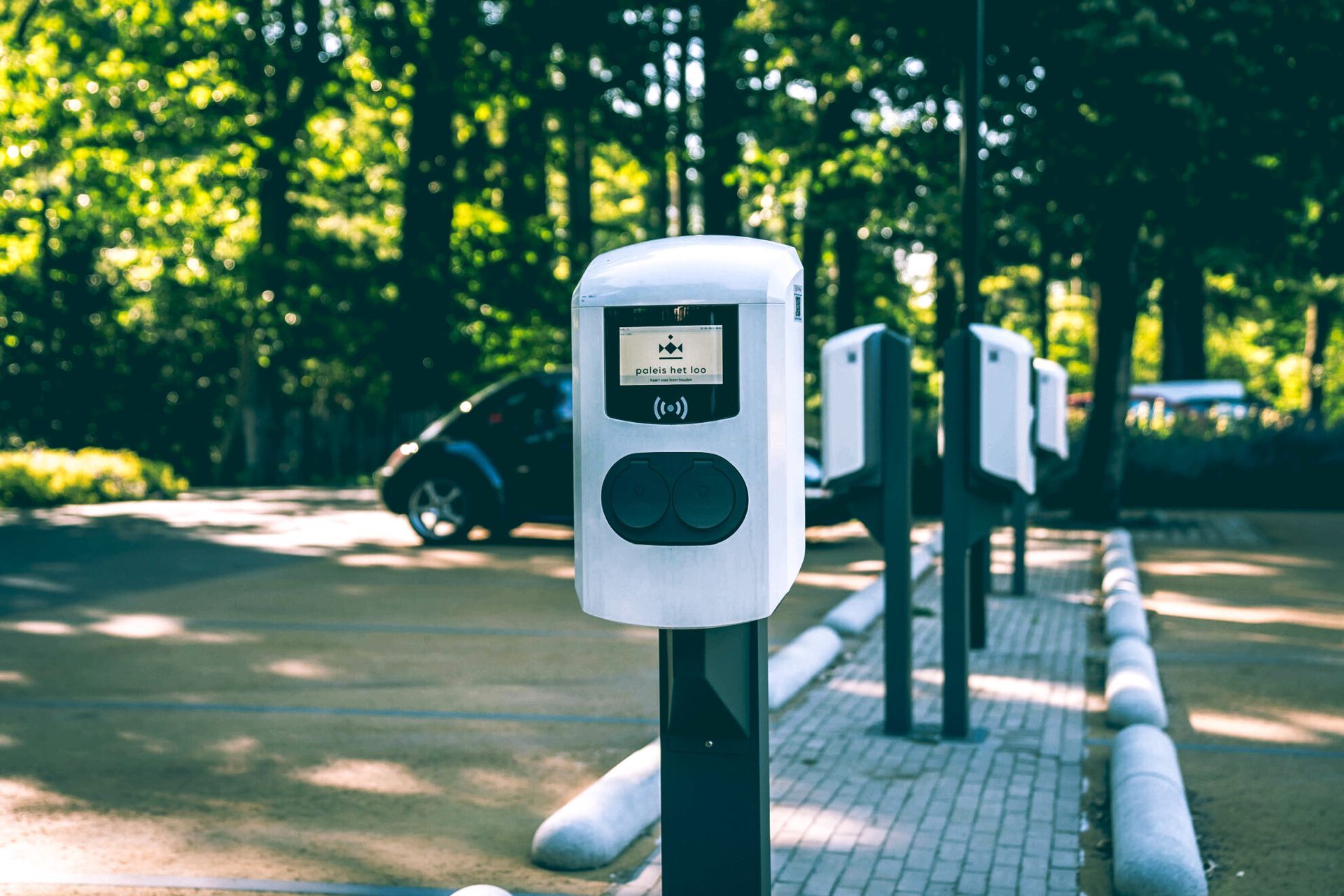 Een rij laadstations voor elektrische auto's op een parkeerplaats.