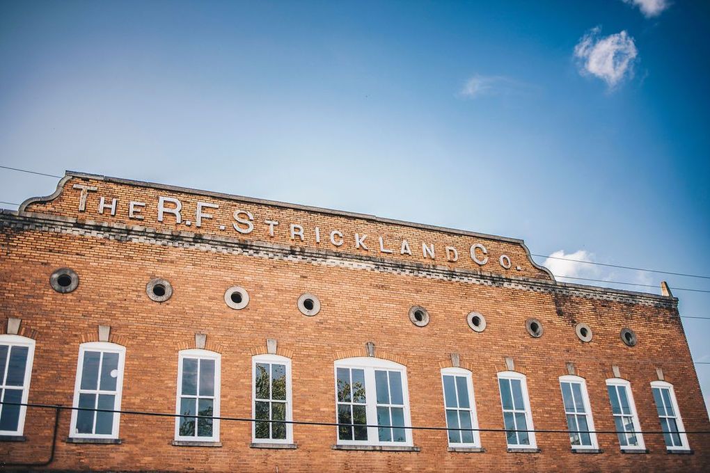 A large brick building with a lot of windows and a blue sky in the background.
