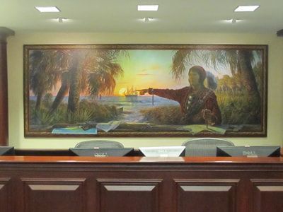 There is a large painting on the wall above the desk.