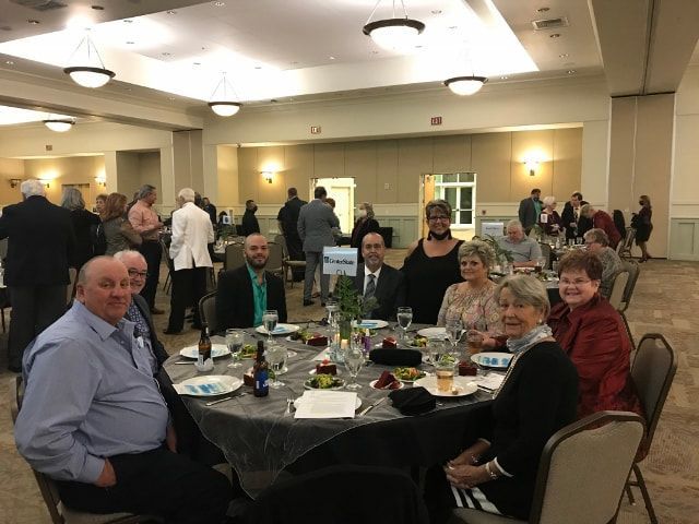 A group of people are sitting at tables in a large room.