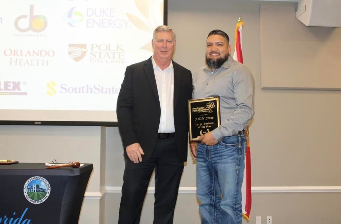 Two men are standing next to each other holding a plaque.
