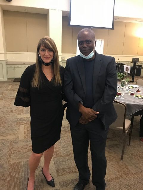 A man and a woman are posing for a picture in a room.