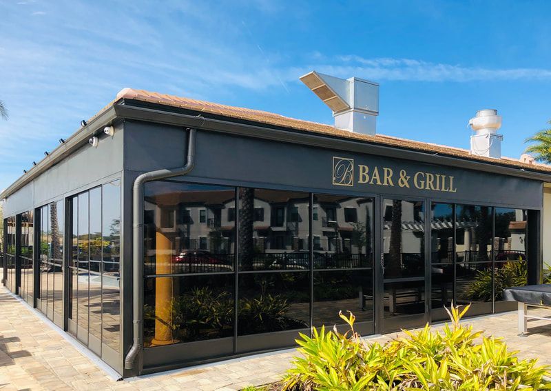 A large building with a lot of windows and a sign that says bar and grill.