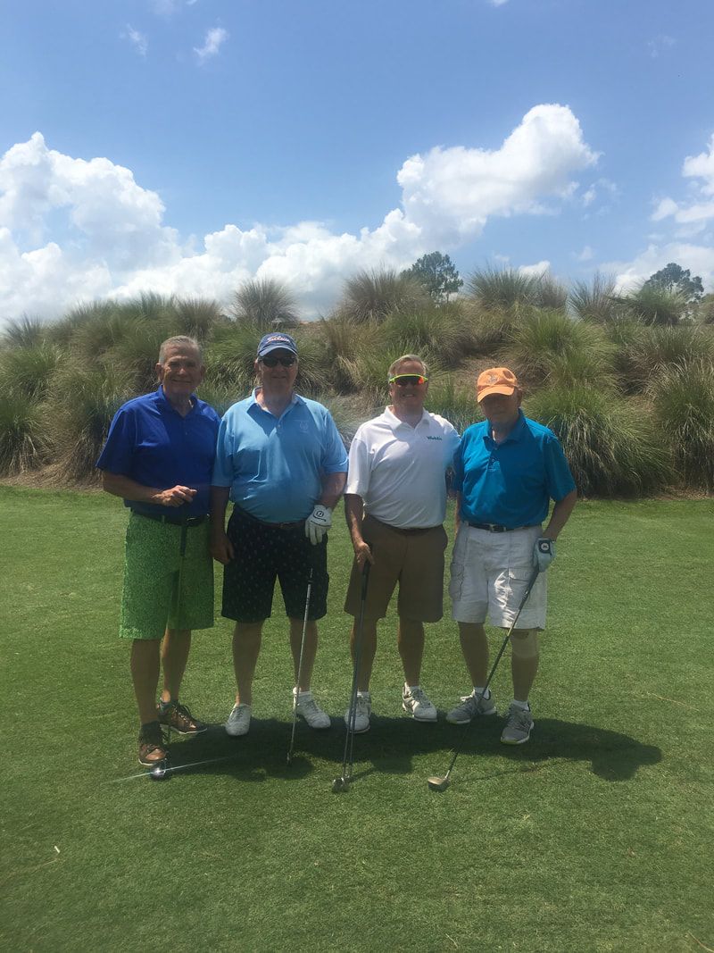 A group of men are posing for a picture on a golf course.