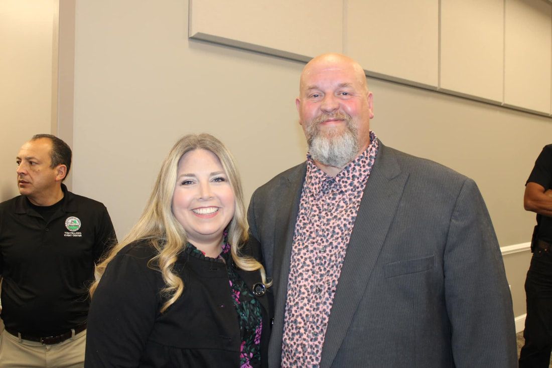 A man and a woman are posing for a picture in a room.