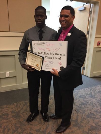 A man holding a sign that says to follow my dreams