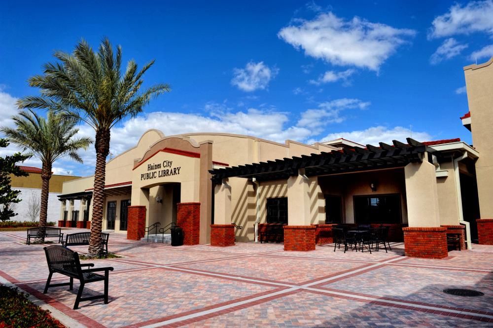 A large building with a pergola and palm trees in front of it.