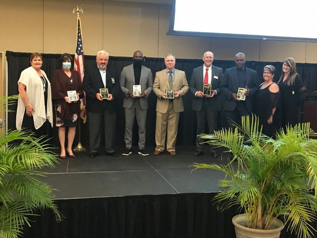 A group of people are standing on a stage holding awards.