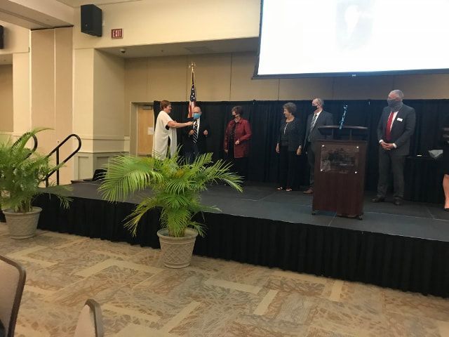 A group of people are standing on a stage in front of a podium.