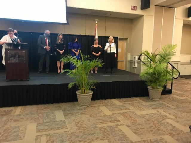 A group of people are standing on a stage in front of a podium.