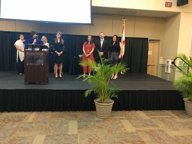 A group of people standing on a stage in front of a podium.