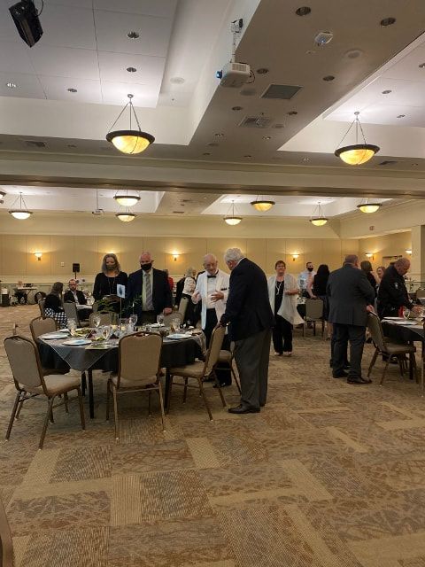 A group of people are sitting at tables in a large room.